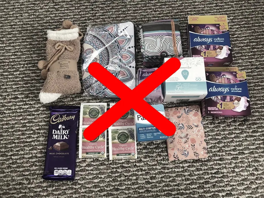 A flat lay of low-quality freebie items, including chocolate, tea, socks, and hygiene products, scattered on a textured surface, marked with a bold red 'X' to symbolize disappointment with cheap, subpar freebies.